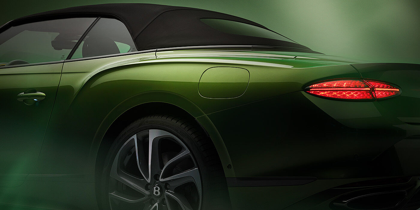 Bentley Perth Bentley New Continental GTC Speed rear haunch and tail lamp in Tourmaline Green paint and dark tint brightware with black hood up and illuminated head lamps