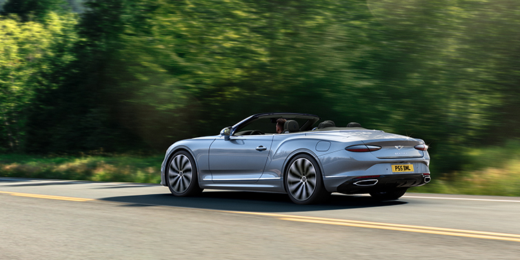 Bentley Perth New Bentley Continental GTC convertible side view in Silverlake paint with 22 inch ten spoke wheels driving dynamically on a country road